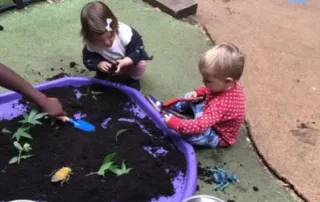 nursery children enjoying messy play outside